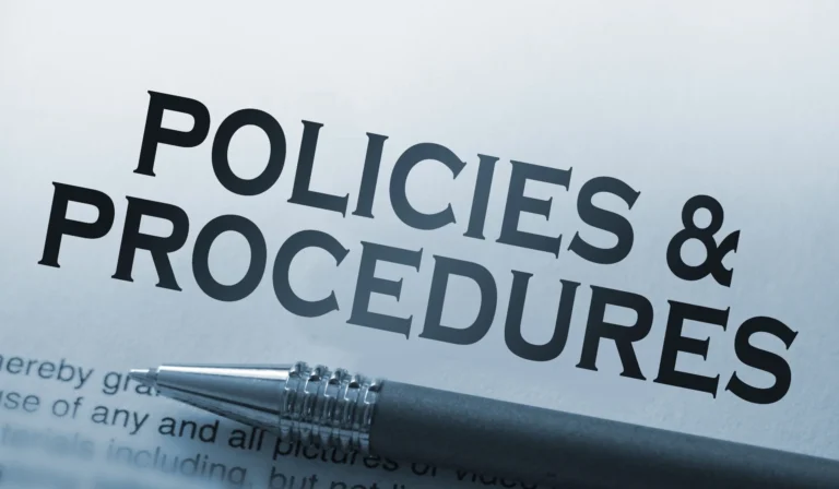 Policies and procedures memo typed on a notebook with pen. Business rules concept.